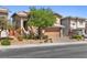 Attractive two-story home with a manicured front yard, stone accents, and a paved driveway leading to a two-car garage at 5594 Trilling Bird Dr, Las Vegas, NV 89135