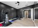 A home gym featuring an elliptical machine, textured black walls and views of the bathroom at 5594 Trilling Bird Dr, Las Vegas, NV 89135