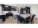 Modern kitchen featuring dark cabinetry, stainless steel appliances, an island, and a stylish dining table at 5594 Trilling Bird Dr, Las Vegas, NV 89135