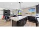 Open concept kitchen with large island, dark cabinetry, and adjacent living area at 5594 Trilling Bird Dr, Las Vegas, NV 89135