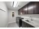 Laundry room with stainless steel washer and dryer with marble countertops and cabinets at 5594 Trilling Bird Dr, Las Vegas, NV 89135