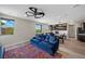 Bright living room featuring hardwood floors, modern ceiling fan, and ample natural light from large windows at 5594 Trilling Bird Dr, Las Vegas, NV 89135