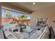 Inviting covered patio featuring a fireplace, comfortable seating, and a view of the pool and landscaped backyard at 5594 Trilling Bird Dr, Las Vegas, NV 89135