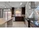 Modern kitchen with stainless steel appliances, dark wood cabinets, mosaic backsplash, and tiled flooring at 6236 Mount Palomar Ave, Las Vegas, NV 89139