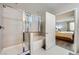 Modern bathroom with a tiled shower, soaking tub, and a peek into the adjacent bedroom at 6445 N Alpine Ridge Way, Las Vegas, NV 89149
