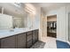 Stylish bathroom with dual sinks, a modern vanity, and a spacious walk-in closet at 6445 N Alpine Ridge Way, Las Vegas, NV 89149