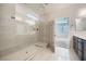 Bright bathroom featuring a glass-enclosed shower, neutral tile, and modern fixtures at 6445 N Alpine Ridge Way, Las Vegas, NV 89149