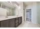 Modern bathroom with dual sinks, a large mirror, and a walk-in closet at 6445 N Alpine Ridge Way, Las Vegas, NV 89149