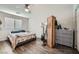 Cozy bedroom with wood-look floors, ceiling fan, and a large window at 6445 N Alpine Ridge Way, Las Vegas, NV 89149