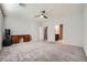 Large bedroom with plush carpeting, neutral walls, and an adjacent bathroom and walk-in closet at 6445 N Alpine Ridge Way, Las Vegas, NV 89149