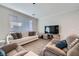 Well-lit living room featuring a plush sofa, comfortable armchairs, and wood-look tile flooring at 6445 N Alpine Ridge Way, Las Vegas, NV 89149