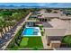 Enjoy a pool, spa, putting green, and palms in this aerial view of a beautifully landscaped backyard at 7095 Falabella Ridge Ave, Las Vegas, NV 89131