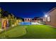 Private backyard oasis featuring a pool, spa, putting green, and covered patio for outdoor entertainment at 7095 Falabella Ridge Ave, Las Vegas, NV 89131