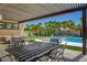 Outdoor patio with a dining set, leading to a pool, spa, and artificial grass at 7095 Falabella Ridge Ave, Las Vegas, NV 89131