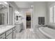 Relaxing primary bathroom featuring dual sinks, soaking tub, and walk-in closet at 7095 Falabella Ridge Ave, Las Vegas, NV 89131
