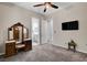 A gray bedroom boasts neutral walls, complemented by an ensuite bathroom and a TV at 7095 Falabella Ridge Ave, Las Vegas, NV 89131