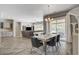 Open-concept dining area with a modern light fixture, stylish chairs, sliding glass doors to the patio, and seamless living space at 7095 Falabella Ridge Ave, Las Vegas, NV 89131