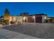 Elegant home exterior with a paver driveway, three-car garage, and professionally landscaped front yard at 7095 Falabella Ridge Ave, Las Vegas, NV 89131