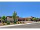 Wide view of the home's front facade displaying desert landscaping and a three-car garage at 7095 Falabella Ridge Ave, Las Vegas, NV 89131