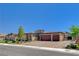 A home with a three-car garage with stone accents and desert landscaping at 7095 Falabella Ridge Ave, Las Vegas, NV 89131