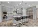 Well-appointed kitchen featuring stainless steel appliances, a large center island with seating, and gray cabinetry at 7095 Falabella Ridge Ave, Las Vegas, NV 89131