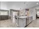 Open-concept kitchen with a center island, granite countertops, stainless steel appliances, and seamless access to the living area at 7095 Falabella Ridge Ave, Las Vegas, NV 89131