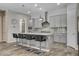 Modern kitchen with gray cabinets, marble countertops, a center island with seating, and stainless steel appliances at 7095 Falabella Ridge Ave, Las Vegas, NV 89131