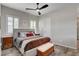 Well-lit main bedroom showcasing a stylish upholstered bed and modern ceiling fan at 7095 Falabella Ridge Ave, Las Vegas, NV 89131