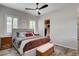 Well-lit main bedroom showcasing a stylish upholstered bed and modern ceiling fan at 7095 Falabella Ridge Ave, Las Vegas, NV 89131