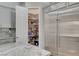 Pantry with organized shelving and ample storage space, complemented by granite countertops and stainless steel refrigerator at 7095 Falabella Ridge Ave, Las Vegas, NV 89131