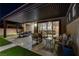 Relaxing covered patio with comfortable seating and outdoor dining area overlooking the backyard at 7095 Falabella Ridge Ave, Las Vegas, NV 89131