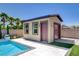 The pool house featuring a garage door, offering space for relaxation, entertainment, and storage at 7095 Falabella Ridge Ave, Las Vegas, NV 89131