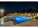 Beautiful backyard featuring a pool, spa, and manicured landscaping illuminated at night at 7095 Falabella Ridge Ave, Las Vegas, NV 89131