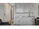 Wet bar area featuring sleek white cabinets and elegant marble-look countertops at 7095 Falabella Ridge Ave, Las Vegas, NV 89131