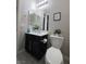 Modern bathroom features a black vanity with white countertop, alongside a toilet and decorative accents at 7114 Superstar St, North Las Vegas, NV 89084