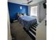 Bedroom featuring a comfortable bed with blue bedding and a striped rug at 7114 Superstar St, North Las Vegas, NV 89084