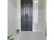 Elegant dark-colored front door with tile flooring and bright sidelight at 7114 Superstar St, North Las Vegas, NV 89084