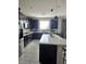 Modern kitchen featuring dark cabinetry, stainless steel appliances, and a spacious island at 7114 Superstar St, North Las Vegas, NV 89084