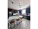 Modern kitchen with dark cabinets, a white countertop island, and seating at 7114 Superstar St, North Las Vegas, NV 89084