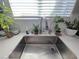 Close-up of a modern kitchen sink with plants, natural light, and subway tile backsplash at 7114 Superstar St, North Las Vegas, NV 89084