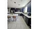 Spacious kitchen with a central island, black cabinets, stainless steel appliances, and tile flooring at 7114 Superstar St, North Las Vegas, NV 89084