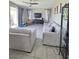 Bright living room with tile flooring, neutral-toned sofas, ceiling fan, and sliding glass doors at 7114 Superstar St, North Las Vegas, NV 89084