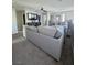 A large sectional sofa in an open area with a TV and neutral carpet flooring at 7114 Superstar St, North Las Vegas, NV 89084