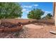 Desert-landscaped backyard featuring a decorative rock feature and a brick patio seating area at 7116 Wonderberry St, Las Vegas, NV 89131