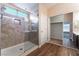 Modern bathroom featuring a glass shower, walk-in closet, dual vanity with a sink and wood-look flooring at 7116 Wonderberry St, Las Vegas, NV 89131