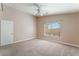 Spacious carpeted bedroom featuring a ceiling fan, neutral paint, and a window providing natural light at 7116 Wonderberry St, Las Vegas, NV 89131