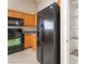 Kitchen featuring wood cabinets, black refrigerator, and black microwave at 7116 Wonderberry St, Las Vegas, NV 89131