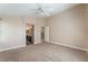 Large main bedroom with carpet, ceiling fan, and bathroom access at 7116 Wonderberry St, Las Vegas, NV 89131