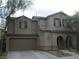 Two story home showcasing the garage and an arched entryway at 7173 Las Colinas Ave, Las Vegas, NV 89179