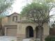Two story home showcasing the garage and an arched entryway at 7173 Las Colinas Ave, Las Vegas, NV 89179